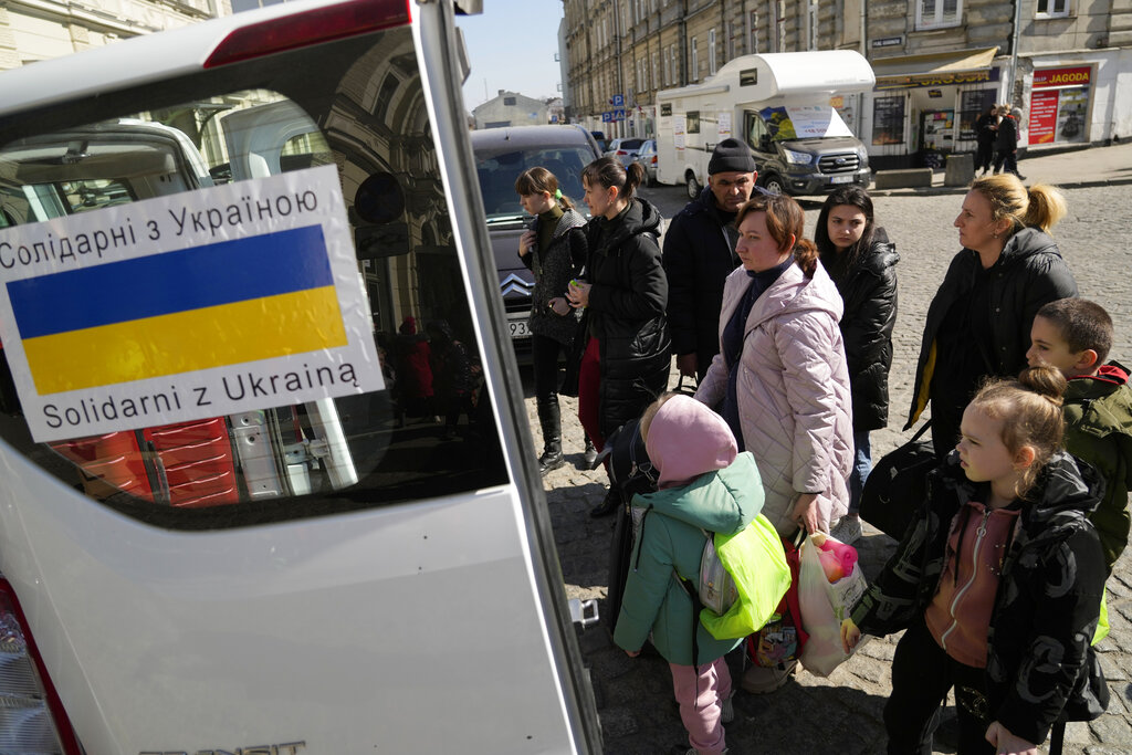 Ukrainian refugees board transport at a square next to a railway station in Przemysl, Poland. Source: AP