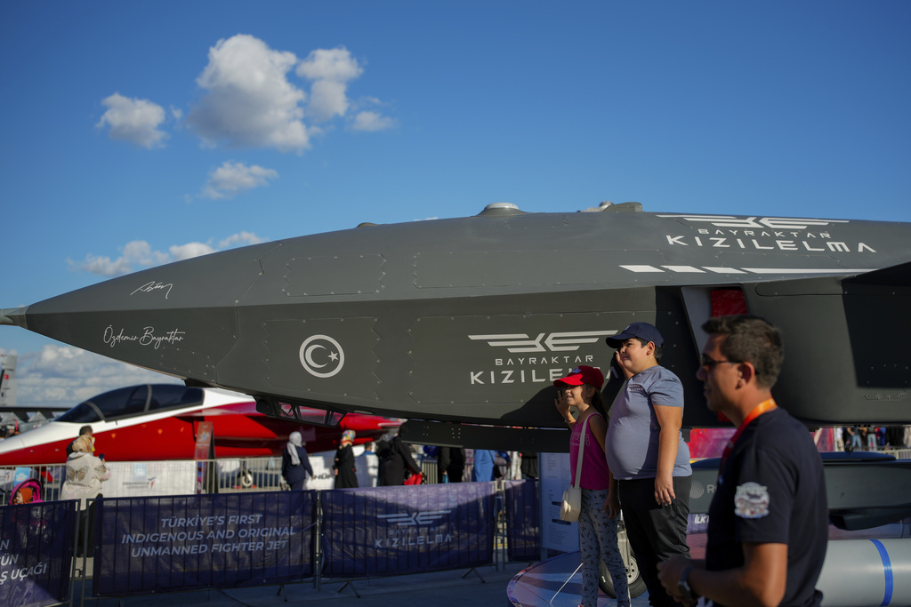 Youngsters pose for photos next to an unmanned combat aircraft Baykar Kizilelma UAV displayed during Teknofest fair, at Ataturk airport, in Istanbul, Turkey. Source: AP.